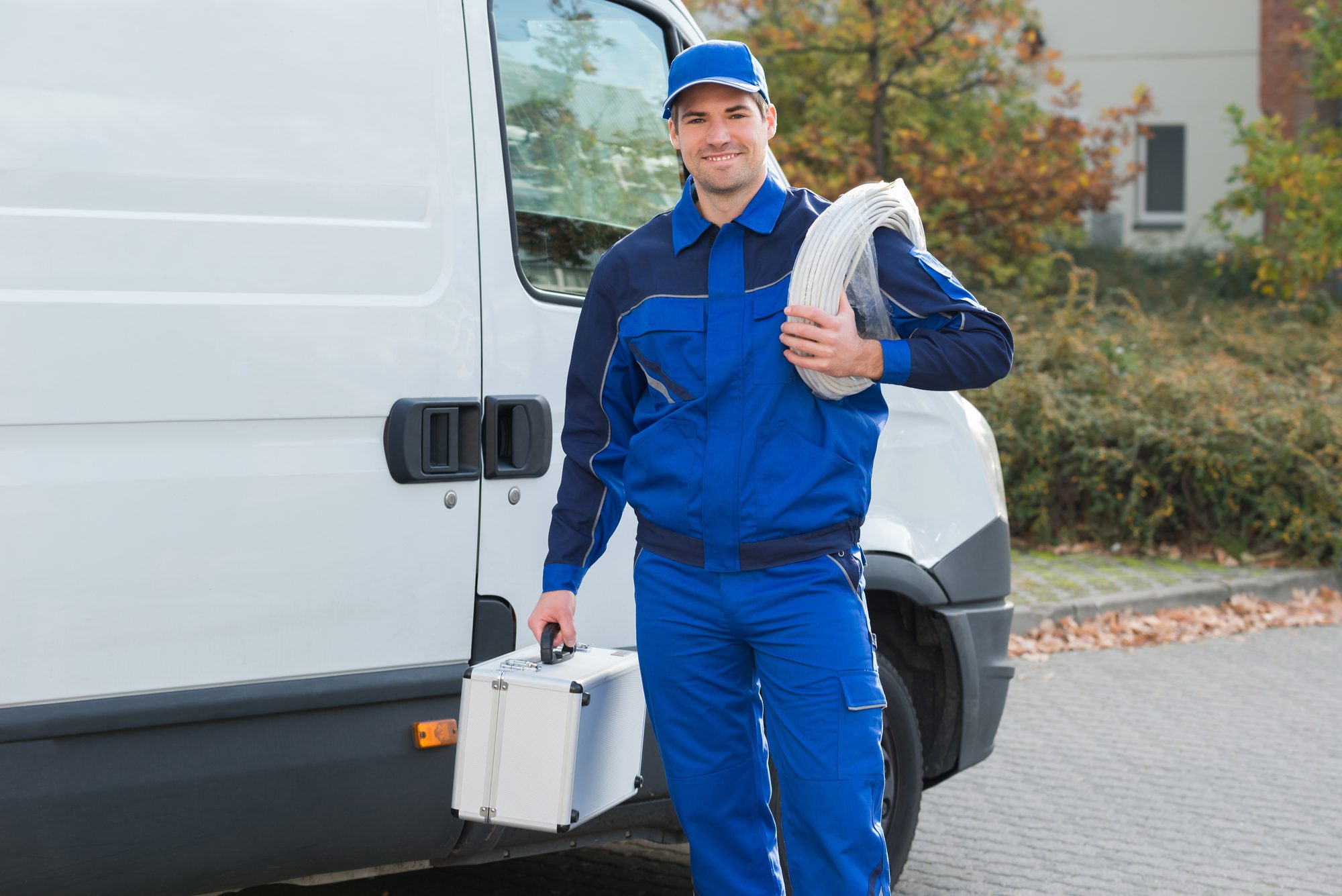 Portrait of Confident Electrician With Cable Coil and Toolbox Standing Outside Truck
